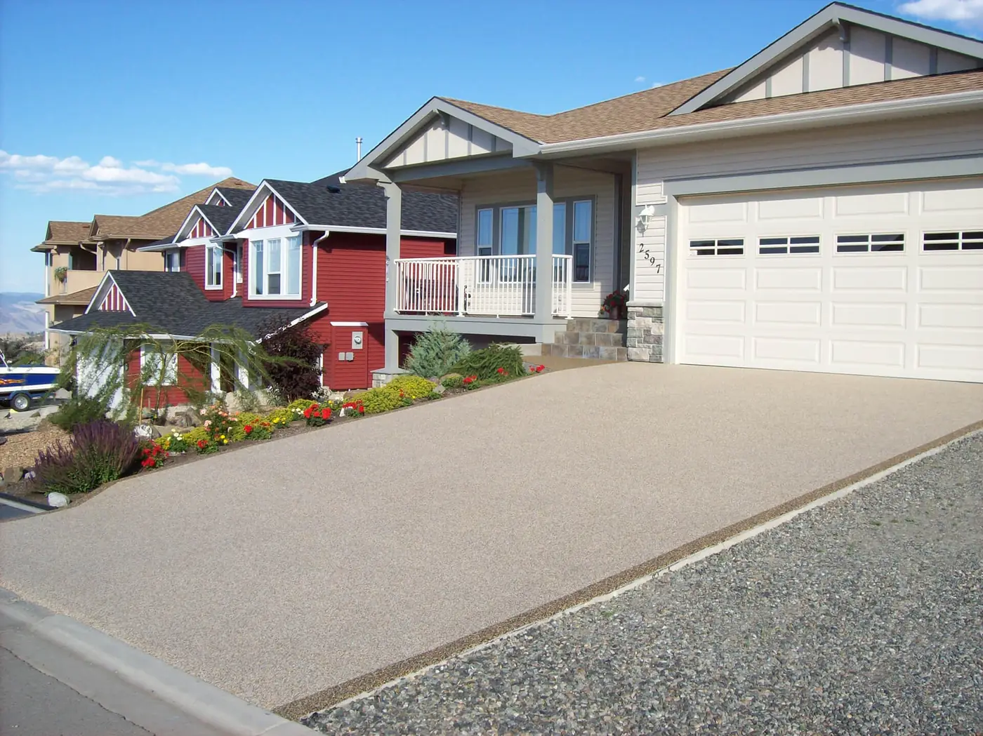 Wide tan Rubber Stone driveway in front of a two-car garage