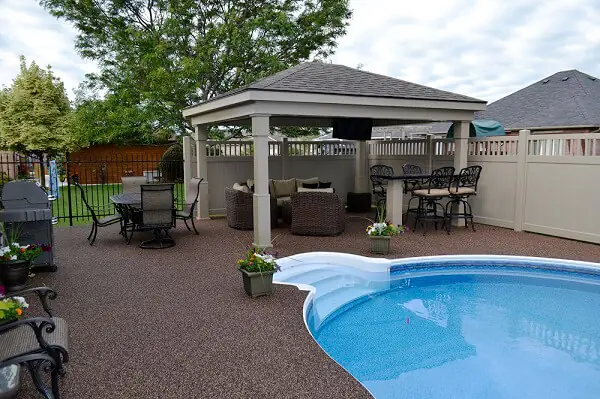 Backyard patio with a pergola and a dark Rubber Stone surface