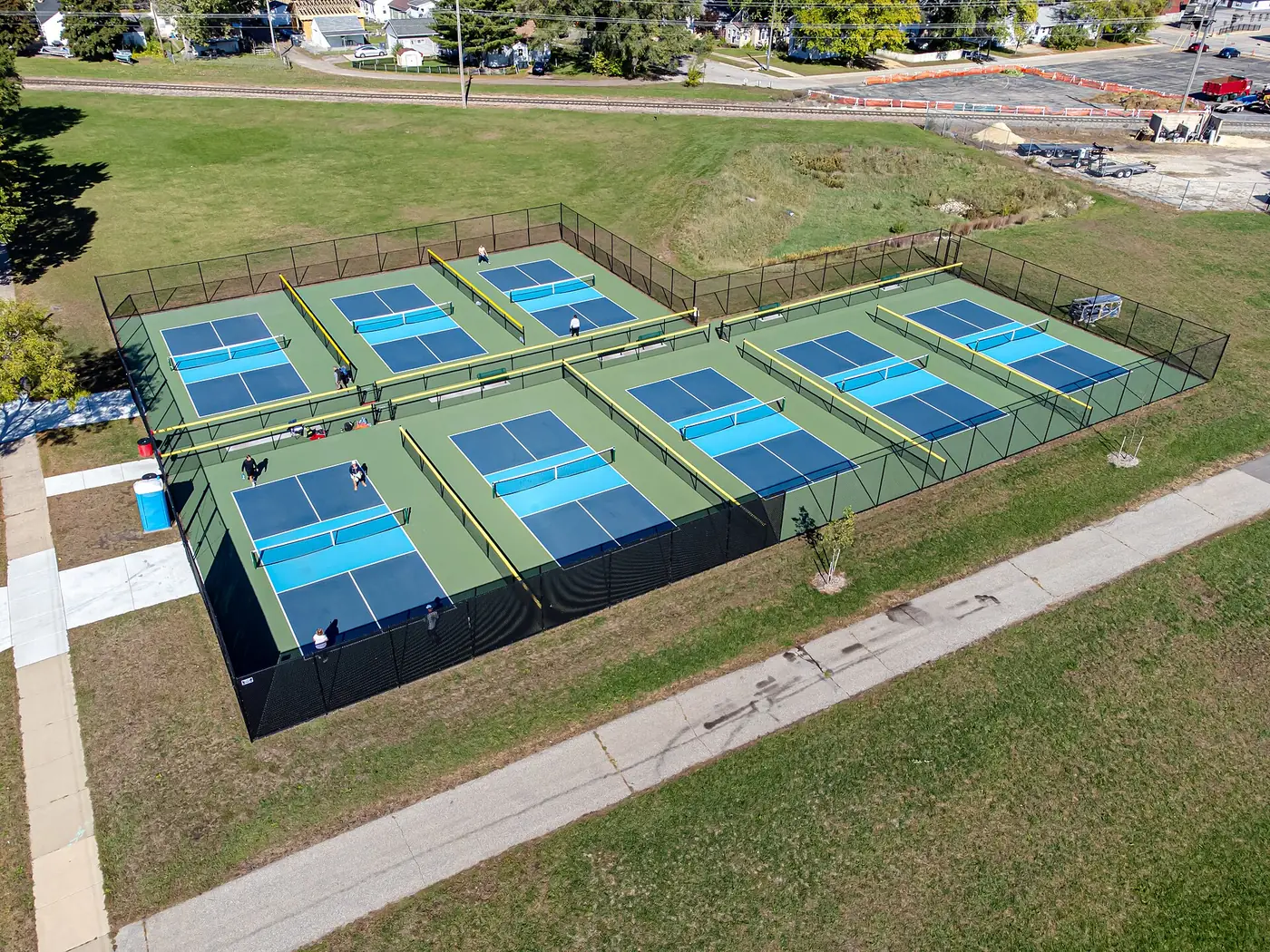 Aerial view of six blue and green pickleball courts